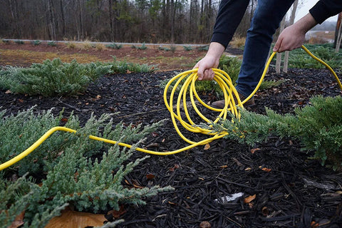 Person using All Purpose Outdoor Extension Cord With A Lit End 50 Feet 12 Gauge 3 Prong SJTW Yellow Weatherproof Vinyl Jacket