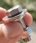 Close-up of a stainless steel hex bolt with flat washer and nut on its threaded shank