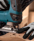 Person using a jigsaw wearing A3 Cut Resistant Work Gloves For Men And Women With Touchscreen Foam Nitrile Coating, close-up view