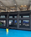 Inflatable Tennis Court Style Tent And Baseball Batting Cage With Blower Portable 19.68 Ft By 9.84 Ft in a warehouse setup