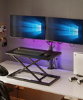 24 Inch Scissor Lift Keyboard And Mouse Riser For Standing Desk Converter on desk with dual monitors and gaming console