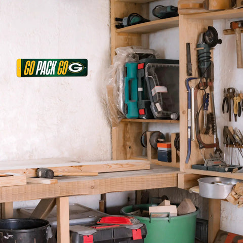 Premium Green Bay Packers Metal Street Sign Wall Art featuring bold team graphics on wall in a workshop setting.