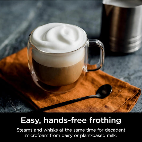 Glass mug of coffee with frothy milk next to spoon showcasing frothing feature of R-ES601 Luxe Café Premier Series 3-In-1 Espresso Machine