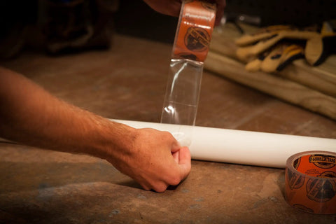 Person applying Crystal Clear Repair Duct Tape 1.88 Inch By 9 Yard Heavy Duty Weatherproof All Purpose Tape on a pipe