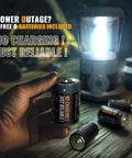 Person holding D battery with glowing Beast 1500 Lumen LED Camping Lantern With 4 D Batteries Included Battery Powered Lantern Flashlight.