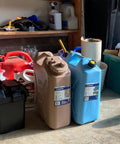 Portable 5 Gallon Military Style Water Jug For Camping And RVs Sand Colored Plastic Beverage And Hydration Dispenser For Outdoor Drinking And Emergency Survival next to blue jug.