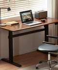 Top Shelf Electric Standing Desk With Ultra Wide Worktop Effortless Height Adjustment Hidden Wire Basket Natural Walnut Finish, shown with laptop and lamp.