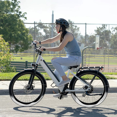 Person biking on a white bicycle with Two Pack 27.5 Inch Self Sealing Bicycle Inner Tubes with AV32mm Schrader Valve on a sunny day.