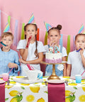Children celebrating at a party with Three Pack Lemon Tablecloths Outdoor Waterproof Rectangle Cover For Indoor And Outdoor Use 54 By 108 Inches Oil Proof Summer Party Kitchen Dining Picnic Barbecue Patio.