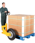 Heavy Duty All Terrain Steel Pallet Truck With Pneumatic Tires And Smooth Steering gliding with boxes on blue pallet.