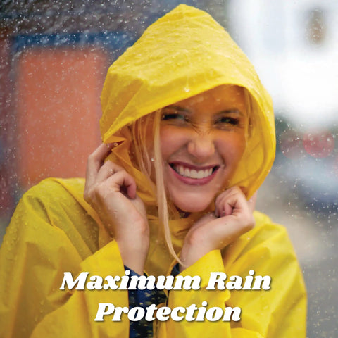 Smiling woman in rain wearing yellow Adult Lightweight Hooded Packable Poncho With Side Snaps For All Weather Protection