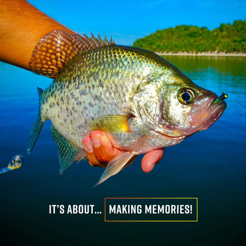 Person holding a large crappie fish near a lake, showcasing a successful fishing trip.