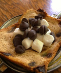 Retro 1945 Style Handheld Cast Aluminum Sandwich Maker And Pie Iron Grill with toasted bread, chocolate chips, and marshmallows.