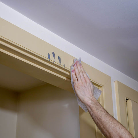 Using Heavy Duty Cleaning Wipes For Every Surface And Hands, 90 Count to remove crayon marks from a door frame indoors.