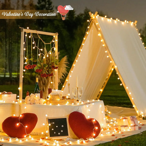 Outdoor Valentine's Day setup with tent adorned in 100 LED Globe String Lights Indoor Outdoor 33ft Warm White With Remote Connectable Fairy Lights