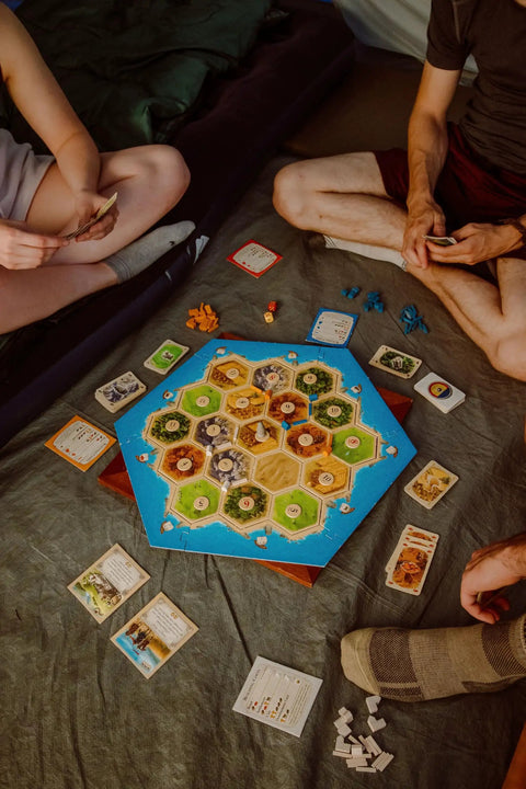 Premium Island Settlement Building Strategy Board Game For Families And Crew Ages 10 Plus Master Resource Trading Expand Territories For An Epic Hella Fun Tabletop Adventure, with game pieces and cards on the floor.