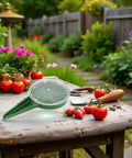 Adjustable Seed Dispenser Hand Tool For Garden Planting And Sowing on wooden table with tomatoes and flowers