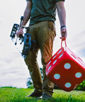Person holding High Roller Foam Archery Target Cube With 21 Bullseyes, 13 Inch by 13 Inch, in outdoor setting