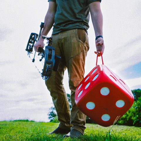 Person holding High Roller Foam Archery Target Cube With 21 Bullseyes, 13 Inch by 13 Inch, in outdoor setting