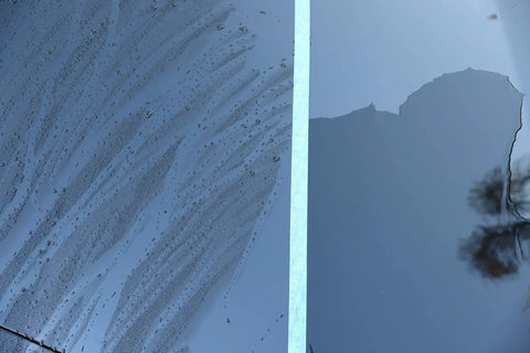 Half-treated surface with Touchless SiO2 Shield Sealant For Paint, Glass And Wheels, showing water beading on one side.
