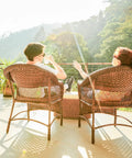 Couple relaxing in outdoor wicker chairs enjoying sunlight, showcasing Hella Durable PE Rattan Repair Cord 7Mm X 131Ft All Season Wicker Chair Replacement String.