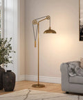 Dope Spoke Wheel Pulley Floor Lamp With Brass Metal Shade in living room next to couch, industrial style lighting with brass finish