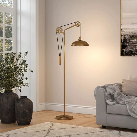 Dope Spoke Wheel Pulley Floor Lamp With Brass Metal Shade in living room next to couch, industrial style lighting with brass finish