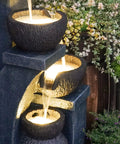 Close-up of four bowl outdoor water fountain with LED lights, modern polyresin floor fountain for garden and patio, three-tier flow