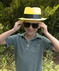 Child wearing Neon Fedora Party Hats And Sunglasses Set For 80s Gangster Theme, Glow Party Accessories, Plastic Fedoras with Cool Sunglasses.