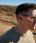 Pro Impulse Hearing Protection In Ear Plugs With Keychain Storage Case for firing range, shooting and hunting, person wearing plugs outside