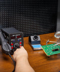 Person using 2 In 1 Hot Air Rework Soldering Station Kit With Desoldering Tool Lead Free Solder Wire Five Soldering Tips Three Hot Air Nozzles Tweezers And Desoldering Pump For Electronics DIYers on circuit board