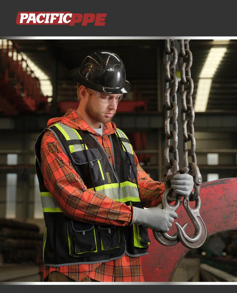 Top Notch Class 1 Black Safety Vest With Ten Roomy Cargo Pockets And 3M Reflective Straps, worn during cargo handling.