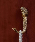 Side view of mermaid shaped metal wall hook in antique aqua finish, holding necklaces, beachy coastal decor coat rack