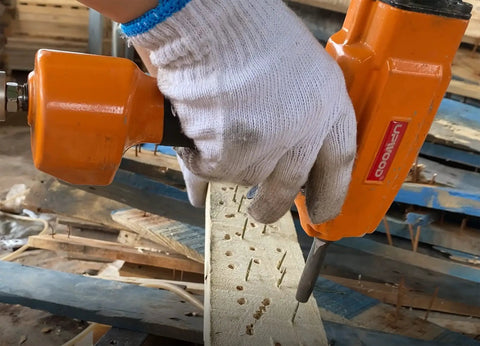 Pro Grade Air Punch Nailer Nail Remover Pneumatic Puller For Denailing And Wood Recycling in use on wooden pallet.