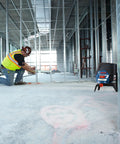 Pro Level 12V Green Beam Cross Line Laser with 100 Foot Reach visible on construction site, used for precise alignment.