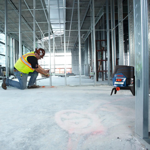 Pro Level 12V Green Beam Cross Line Laser with 100 Foot Reach visible on construction site, used for precise alignment.