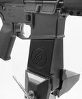 Custom Rifle Vise Block for Gun Cleaning Stations and Safe Rooms, Go-To Heavy Duty Horizontal Clamp Mounts for Quick Rifle Maintenance, Made in USA, Fits Various Rifles, Durable Plastic Vise Block for Home Gun Safe Organization. AR-style rifle clamped in black vise block for maintenance.