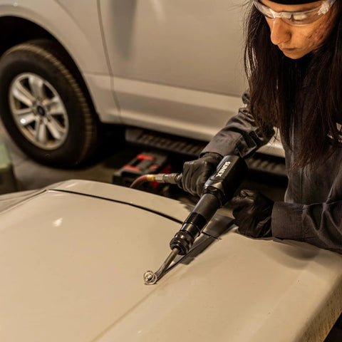 Person using Long Barrel Air Hammer For Heavy Duty Demolition And Workshop Use, 2300 Blows Per Minute on a vehicle door.