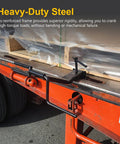 Heavy Duty Steel Cargo Strap Winder For Flatbed Trailers Portable Tie Down Roller With Industrial Powder Coat Fits Four Inch Winch Straps Corrosion Resistant Hand Winder Tool For Trucks And Warehouses mounted on orange flatbed trailer