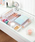 SimpleSort 10 Piece Stackable Clear Drawer Organizer Set with makeup and office supplies on a vanity desk