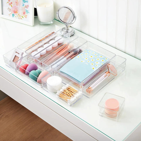 SimpleSort 10 Piece Stackable Clear Drawer Organizer Set with makeup and office supplies on a vanity desk