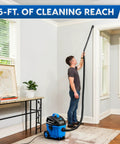 Man using 4 Gallon Wet Dry Vacuum With 5 Peak HP Two Stage Industrial Motor for cleaning high wall areas in a room.