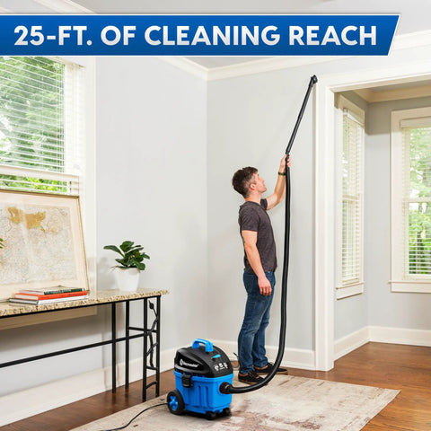 Man using 4 Gallon Wet Dry Vacuum With 5 Peak HP Two Stage Industrial Motor for cleaning high wall areas in a room.