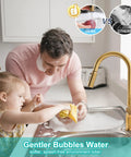 Smooth Operator Brushed Gold Kitchen Faucet With Sleek Single Handle And Slick Pull Down Sprayer For Zero Hassle Cleaning Featuring Splash Proof Three Way Spray For Quick One Or Three Hole Install, shown in use with father and child at sink.
