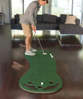 Man using Indoor Putting Green For Home Golf Practice With Realistic True Roll, Three Cups And Workable Bunkers, 3x9 Feet