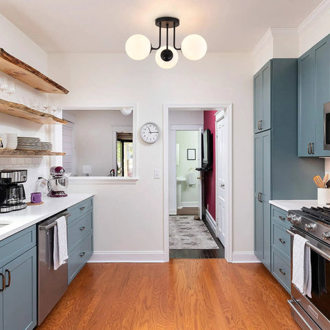 Three Light Mid Century Matte Black Semi Flush Ceiling Light With Opal Milk Glass Globes in a modern kitchen scene