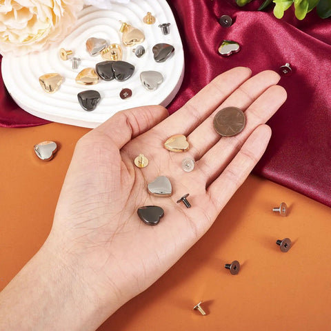 Hassle Free 15 Piece Heart Shaped Leather Rivets Kit Dope Alloy Studs And Screws in hand with coin for size reference.