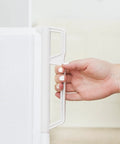 Close-up of hand holding Retractable Indoor Outdoor Pet Safety Gate For Doorways And Stairs Up To 54 Inches Ultra Space Saving Super Easy To Move.