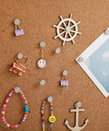 Badass 100 Piece Heavy Duty Flat Head Thumb Tacks With A Sharp Silver Finish And A Nifty Storage Canister used to secure notes and decor on corkboard.