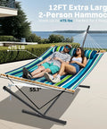 Two Person Quilted Outdoor Hammock With Stand Detachable Pillow And Bamboo Spreaders Portable Hammock With Carrying Bag Heavy Duty Frame Perfect For Yard Patio Or Outdoor Chill Dark Cyan shown in use on a patio with two people lounging